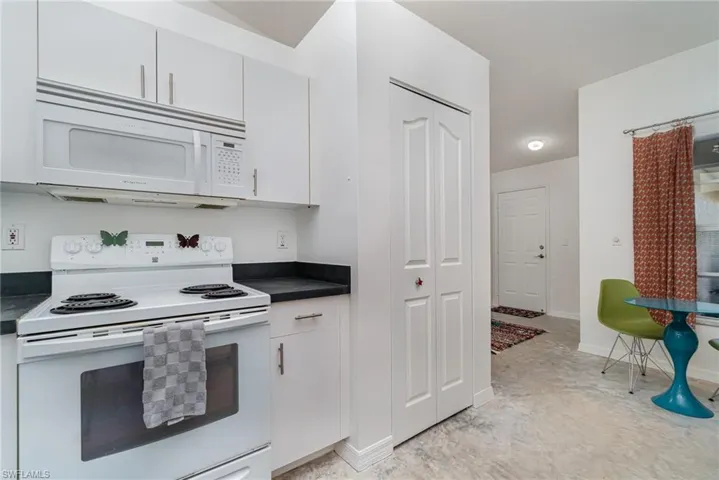 Kitchen featuring white cabinets, white appliances, and pantry