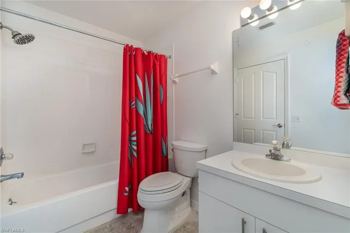 Bathroom with shower/bath combo, concrete floor and two access doors