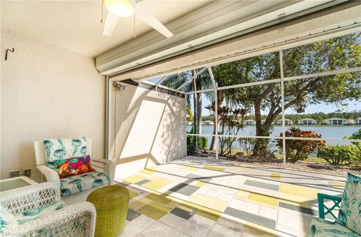 Lanai featuring ceiling fan, lake view, and electric shutter