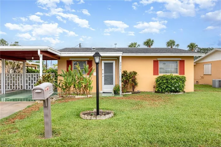 View of front of home with stucco siding and an attached carport