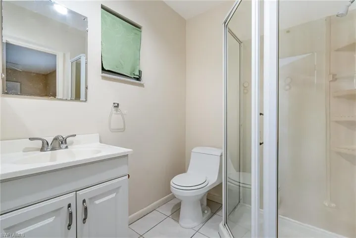 Bathroom with vanity, a stall shower, and light tile patterned floors