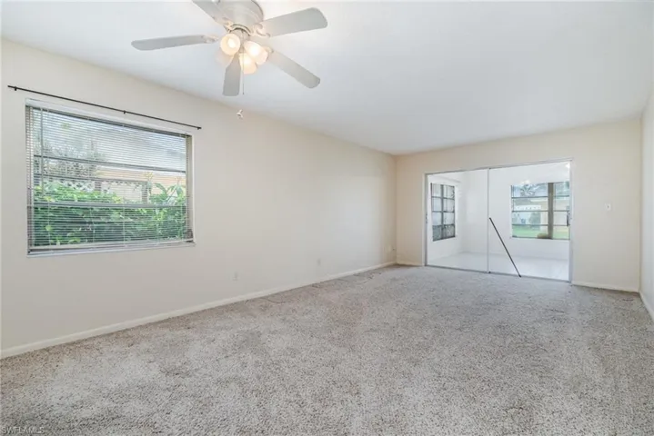 Carpeted spare room with plenty of natural light and ceiling fan