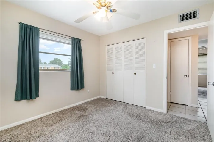 Unfurnished bedroom featuring light carpet, a closet, and ceiling fan