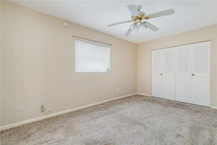 Unfurnished bedroom with carpet floors, a closet, and a ceiling fan