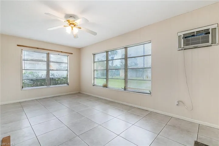 Spare room featuring a ceiling fan, wood walls, and light tile patterned floors