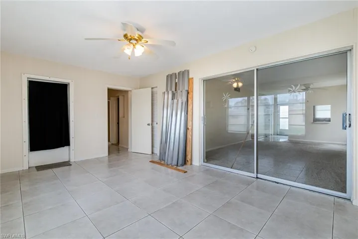 Unfurnished bedroom with ceiling fan, a closet, and light tile patterned floors