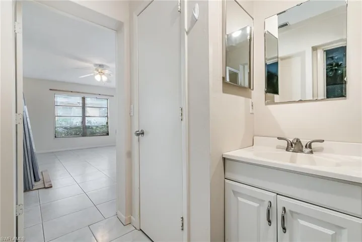 Bathroom with vanity, light tile patterned floors, and a ceiling fan