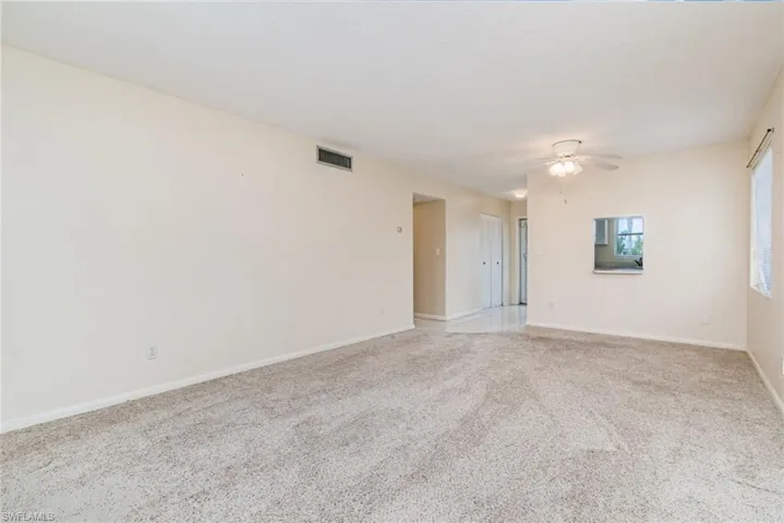 Spare room featuring light colored carpet and ceiling fan