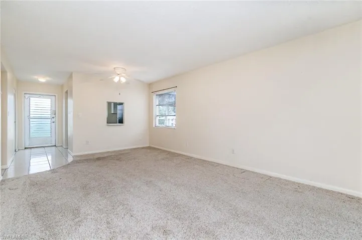 Unfurnished room featuring light carpet and ceiling fan