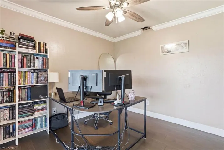Room featuring wood-finish flooring, crown molding, and a ceiling fan with integrated lighting