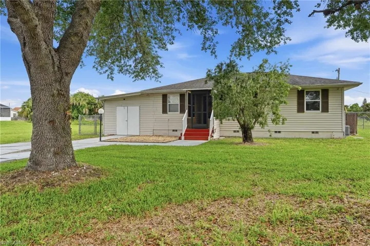 Ranch-style residence featuring siding exterior, a screened entry, and a paved driveway