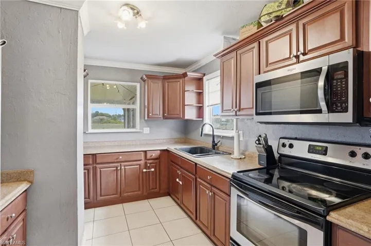 Kitchen featuring wood-finish cabinetry, light-toned countertops, and tile flooring