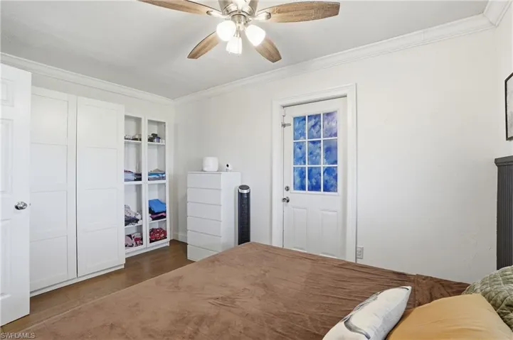 Interior space featuring wood-finish flooring, white walls, and crown molding