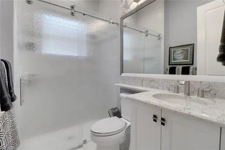Well-appointed second guest bathroom with contemporary sliding glass shower door
