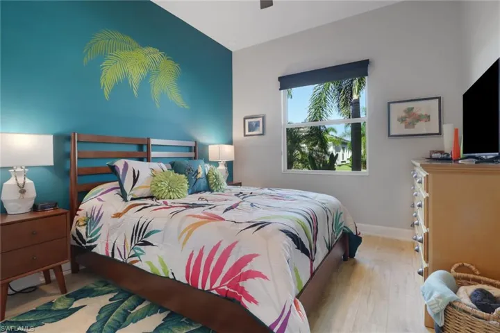 Well-appointed guest bedroom features a large window, designer lighting, and ample closet space