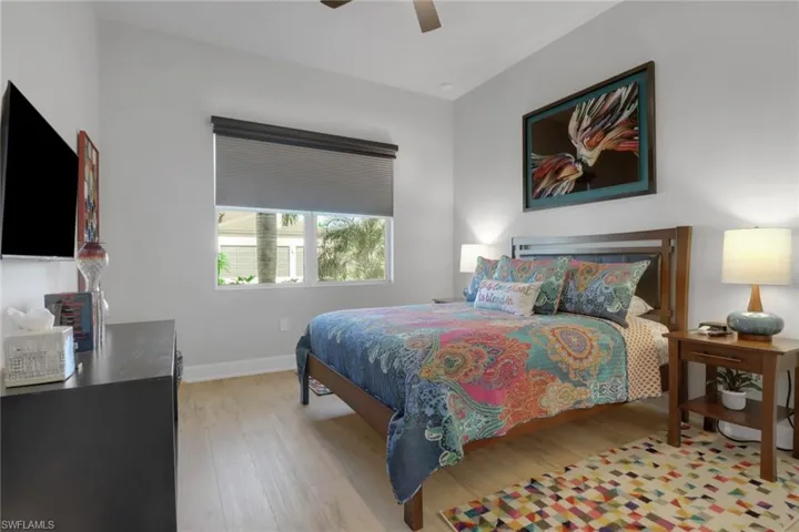 Bright and inviting guest suite featuring motorized window treatments, designer ceiling fan, and generous closet space