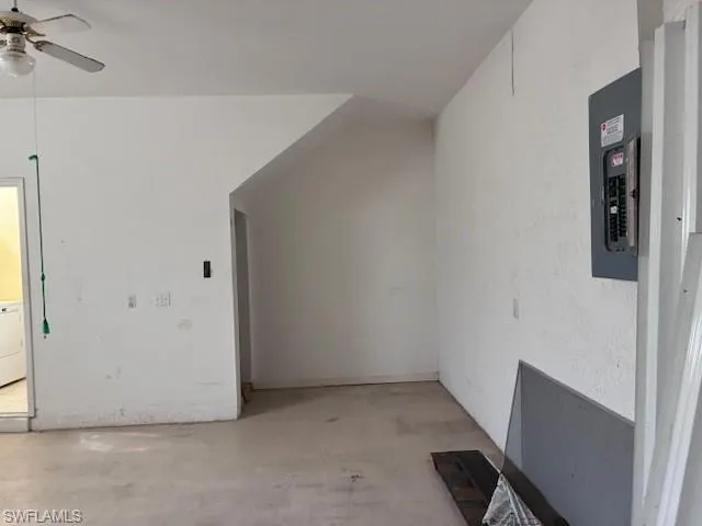 Additional living space with concrete flooring, ceiling fan, electric panel, and washer / clothes dryer
