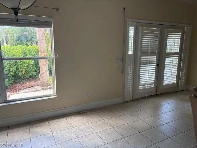Unfurnished room with french doors and light tile patterned floors