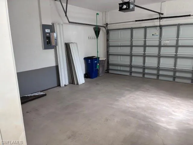 Garage featuring electric panel and a garage door opener