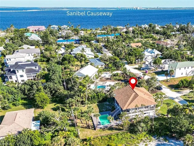 Aerial perspective of suburban area featuring a large body of water and a pool