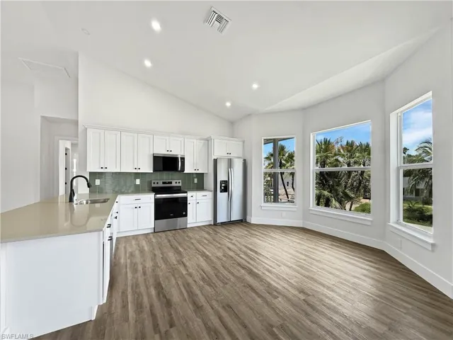 Kitchen featuring backsplash, stainless steel appliances, windows with natural lighting and recessed lighting
