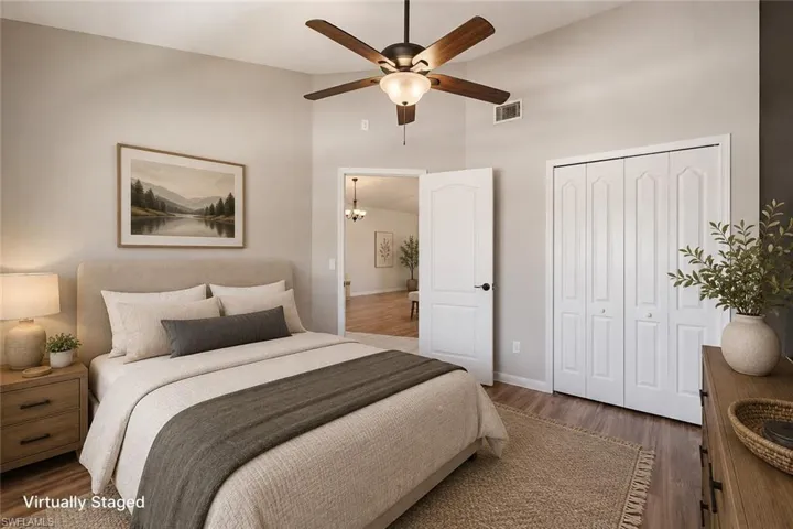 Vaulted ceiling with a ceiling fan, wood-finish flooring, and white bifold closet doors