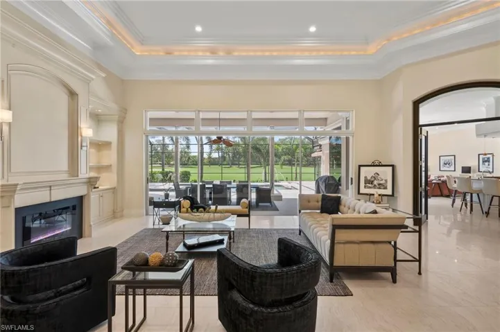 Common area with a sunroom, crown molding, a towering ceiling, and recessed lighting