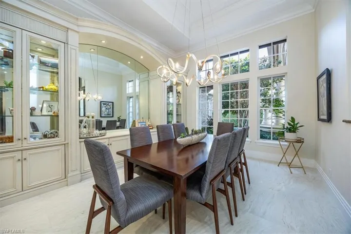 Dining area with a chandelier, ornamental molding, a high ceiling, and recessed lighting