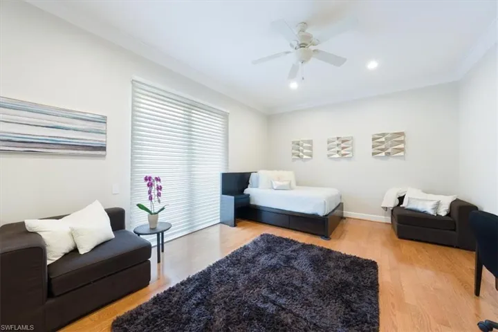 Bedroom with ornamental molding, light wood-type flooring, a ceiling fan, and recessed lighting