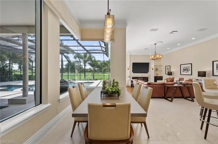 Dining area with ornamental molding, a chandelier, a fireplace, a sunroom, and recessed lighting
