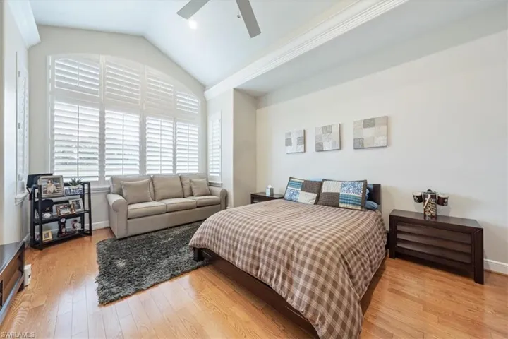 Bedroom with lofted ceiling, light wood-style flooring, and ceiling fan