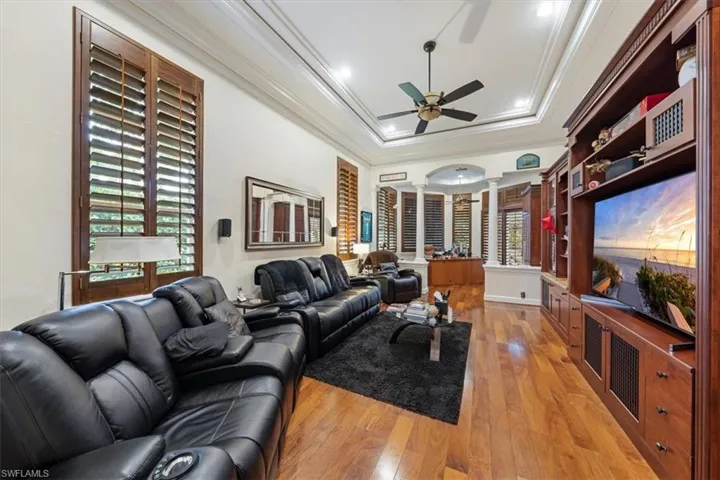 Living area with light wood finished floors, a tray ceiling, ornamental molding, a ceiling fan, and recessed lighting