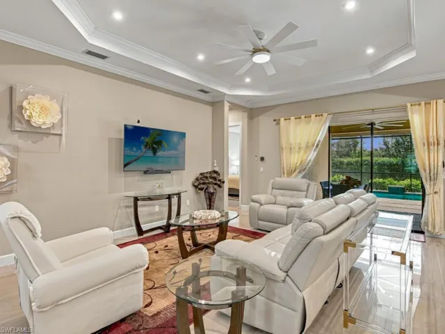 Tray ceiling with recessed lighting, ceiling fan, and large-format tile flooring