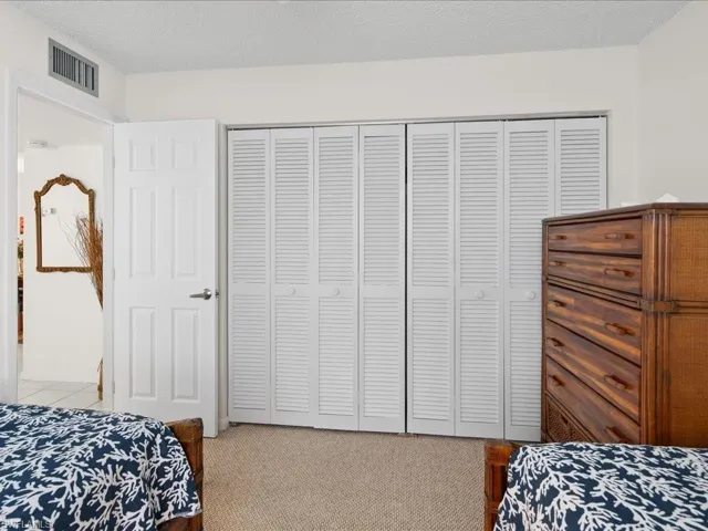 Bedroom with a closet, light colored carpet