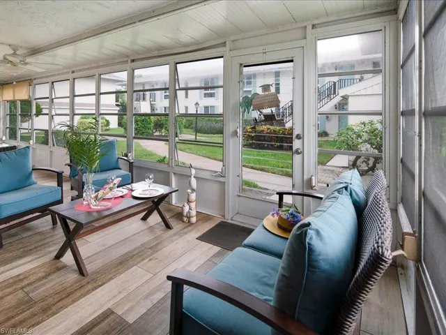 Sunroom with a ceiling fan and view