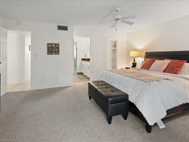 Spacious bedroom and connected bathroom, light carpet