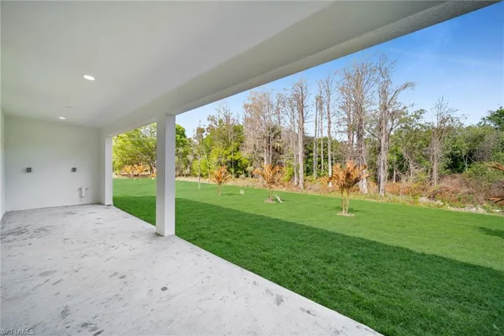 View of grassy yard with a patio area
