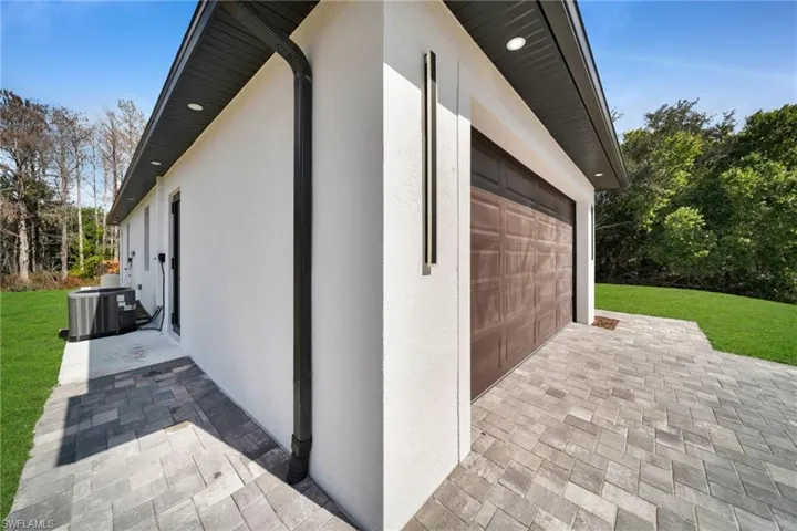 View of side of home featuring stucco siding, a lawn, and a patio area