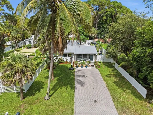 Single-story residence featuring a metal roof, screened front entry, and a paver driveway