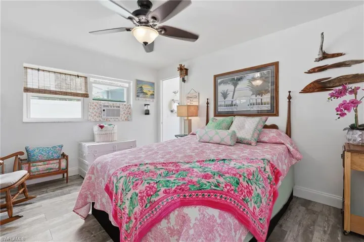 Spacious room featuring LVP flooring, white walls, and a ceiling fan with integrated lighting