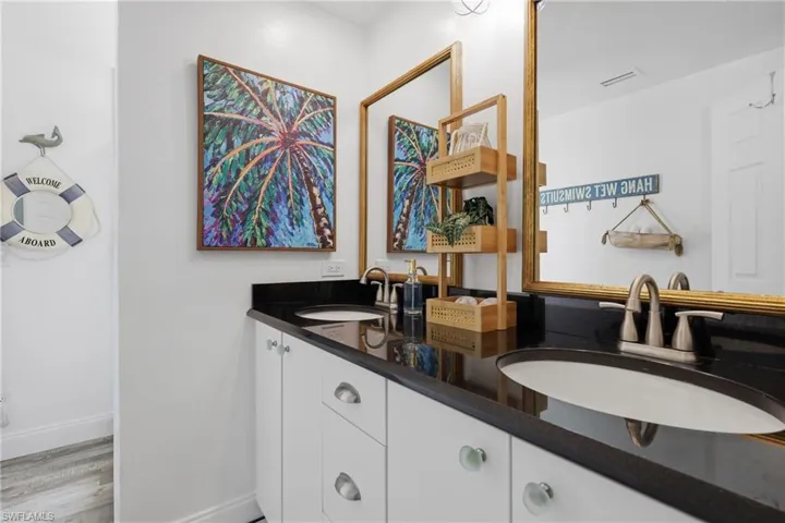 Dual vanity with dark countertop, undermount sinks, and brushed nickel fixtures