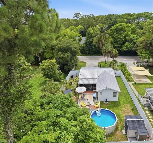 Fenced backyard featuring an above-ground pool, patio area, and a storage shed