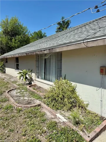 View of property exterior with stucco siding and a shingled roof