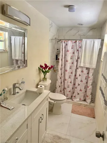 Bathroom featuring vanity, a stall shower, and a textured wall