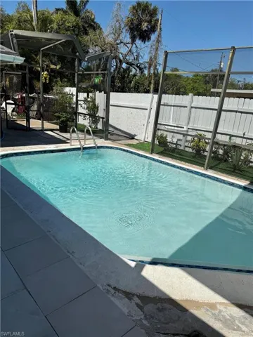 View of pool with a fenced backyard and a sunroom