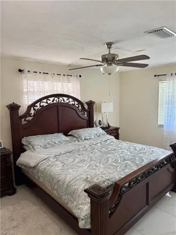 Bedroom with a ceiling fan and a textured ceiling