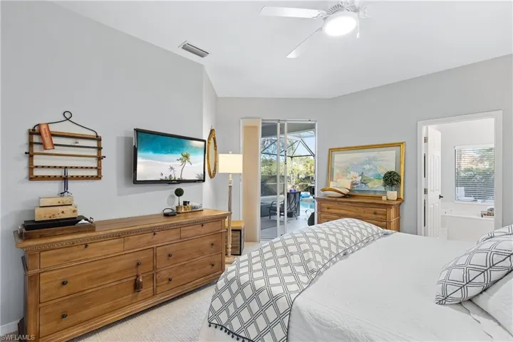 Bedroom featuring access to outside, ensuite bath, and ceiling fan