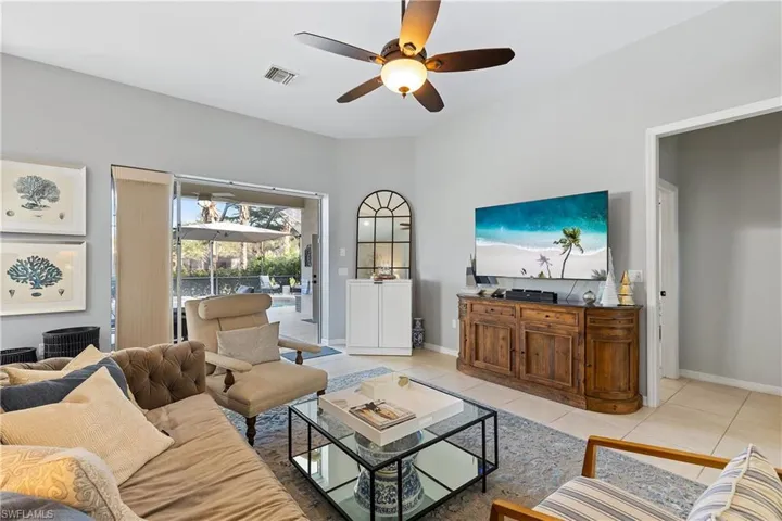 Living room featuring light tile patterned floors and ceiling fan