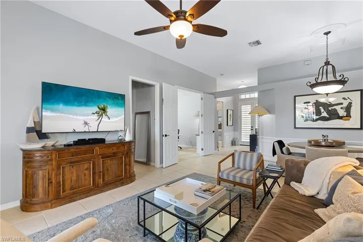 Living room with light tile patterned floors and ceiling fan