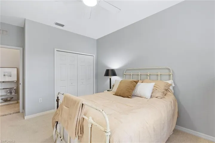 Bedroom with light carpet, a closet, and ceiling fan